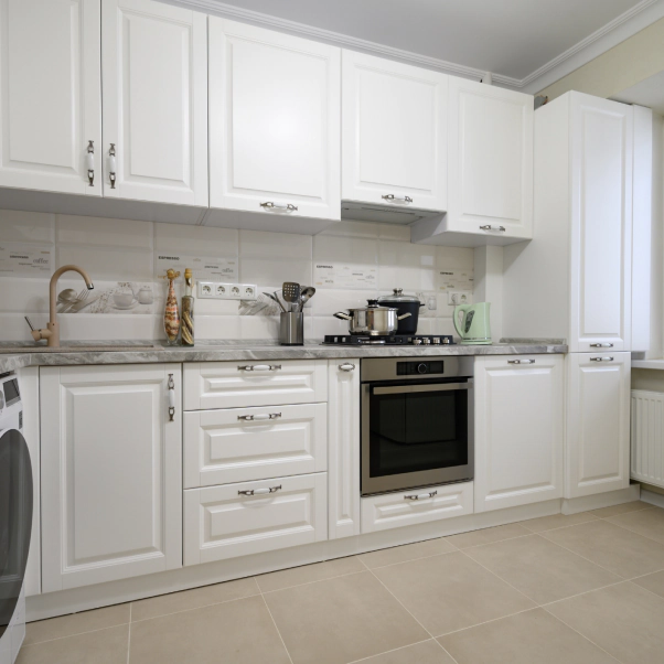 white kitchen with a white cabinetry and a platinum stove